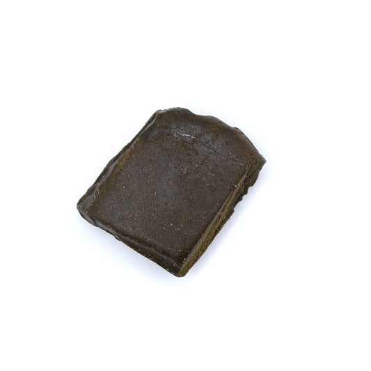 Brun hashplade (hashish) blok isoleret på hvid baggrund set ovenfra.