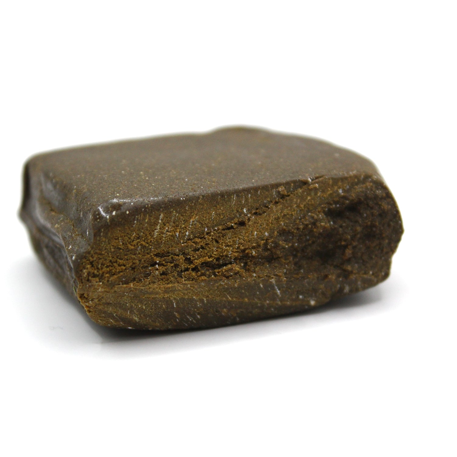Mørkebrun hashplade (hashish) blok med kompakt presset struktur og synlig indre tekstur fotograferet på hvid baggrund.