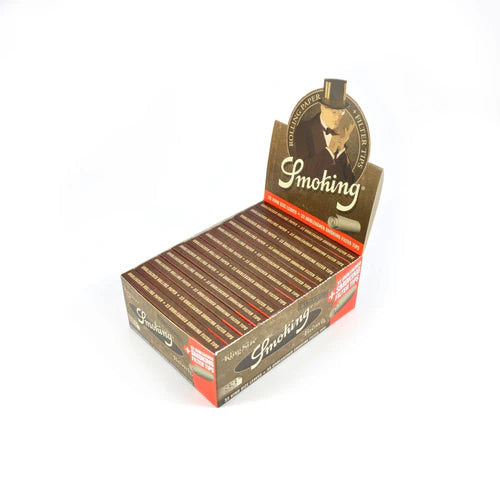Smoking Brown ublegede rolling papers i displayæske med flere pakker naturlige cigaretpapirer fotograferet fra let sidevinkel på hvid baggrund.