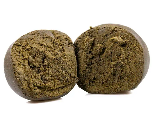 Slaskeren hash delt i to stykker med mørk yderside og smuldrende brun indre struktur vist i close-up fra frontvinkel på hvid baggrund.